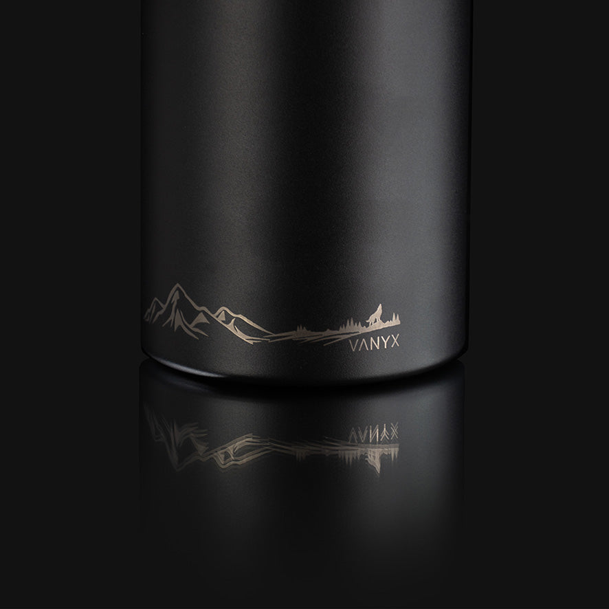 Detailansicht der Vanyx Edelstahl-Trinkflasche mit Gravur von Bergen, Wald und Wolf